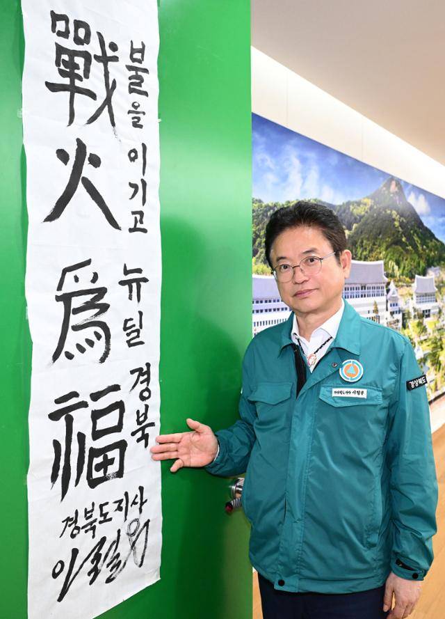 이철우 경북도지사가 8일 한국일보 인터뷰에 앞서 집무실 출입문에 직접 써 붙인 휘호에 대해 설명하고 있다. 10만ha를 태운 산불을 완전 진화한 후 쓴 휘호에 산불과 싸워 지역 소멸을 막겠다는 의지를 담았다고 했다. 경북도 제공