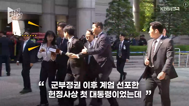 12일 오전 서울중앙지방법원에 출석한 윤석열 전 대통령에게 KBS 기자가 질문하자 경호원이 뒤에서 팔을 잡아 끌고 있다. /KBS