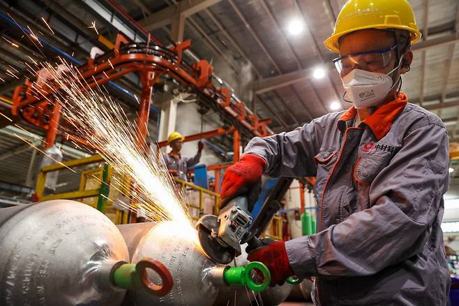 지난 8일 중국 동부 장시성 루이창의 한 공장에서 한 직원이 수출용 자동차 가스 실린더를 생산하고 있다. (위 기사와 직접적인 연관 없음.) / 사진=AFP