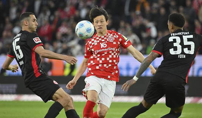 Mainz midfielder Lee Jae-sung, center, vies for the ball during a Bundesliga match against Frankfurt at Mewa Arena in Mainz, Germany, on May 4. [AP/YONHAP]