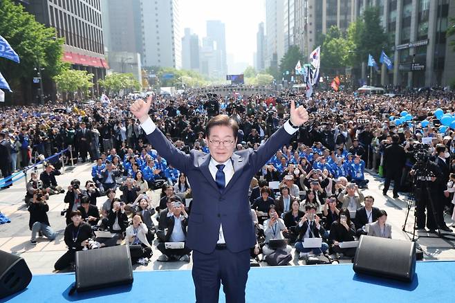 더불어민주당 이재명 대선 후보가 6·3 대통령선거 공식 선거운동 첫날인 12일 '빛의 혁명'을 상징하는 공간인 서울 광화문 청계광장에서 첫 유세를 시작하며 두 팔을 번쩍 들고 있다.