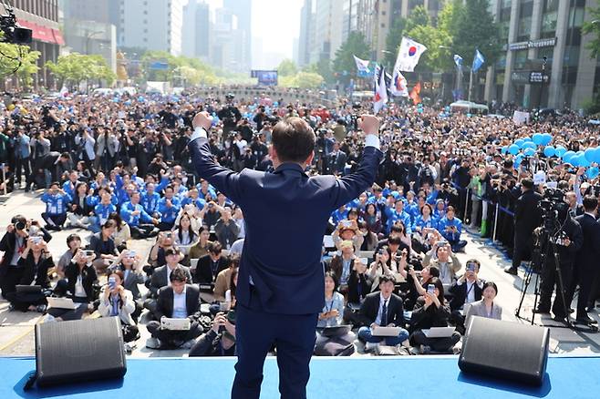 더불어민주당 이재명 대선 후보가 6·3 대통령선거 공식 선거운동 첫날인 12일 서울 청계광장에서 열린 중앙선거대책위원회 출정식에서 두 팔을 들어 올리며 시민들에게 인사하고 있다. [사진 출처 = 연합뉴스]