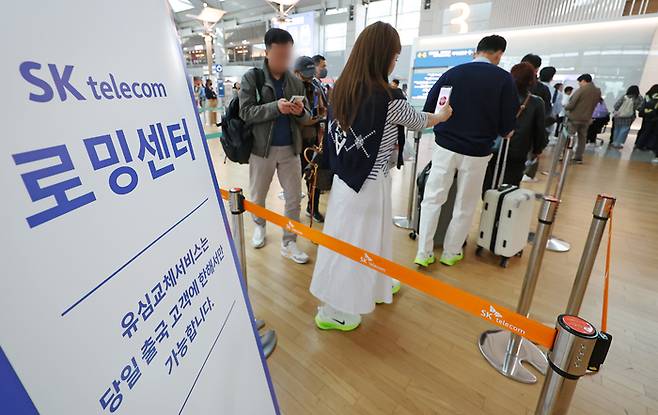 지난 4일 인천국제공항 제1여객터미널 출국장에 마련된 SK텔레콤 로밍센터에서 출국자들이 유심 교체를 위해 줄을 서고 있다. [사진 = 연합뉴스]
