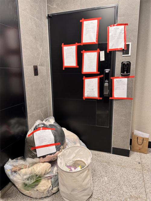 수원시 팔달구 한 빌라 복도에  A씨의 짐이 비닐봉투와 수납함 등에 담긴 채 문 밖에 놓여있다. 수원 일가족 전세사기 사건의 피해자인 A씨는 보증금을 돌려받지 않은 상황에서 집이 단기임대 매물로 올라왔다며 ‘주거침입 피해’를 주장하고 있다. [제공=A씨]