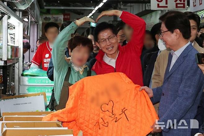 제21대 대통령선거 공식 선거운동 첫날인 12일 오전 김문수 국민의힘 대선 후보가 서울 송파구 가락시장을 방문해 상인에게 사인을 해주고 기념촬영을 하고 있다./사진=뉴시스