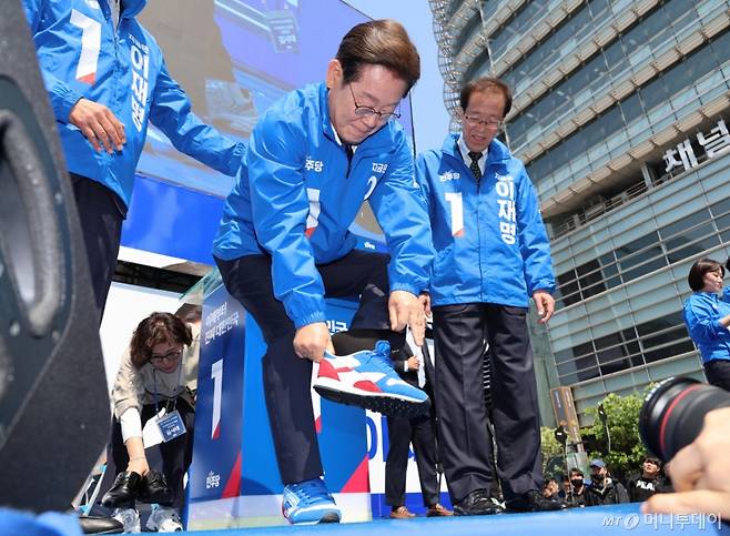 [서울=뉴시스] 조성우 기자 = 이재명 더불어민주당 대선후보가 제21대 대통령선거 공식 선거운동이 시작된 12일 오전 서울 청계광장에서 열린 중앙선거대책위원회 출정식에서 운동화를 신고 있다. (공동취재) 2025.05.12. photo@newsis.com /사진=류현주