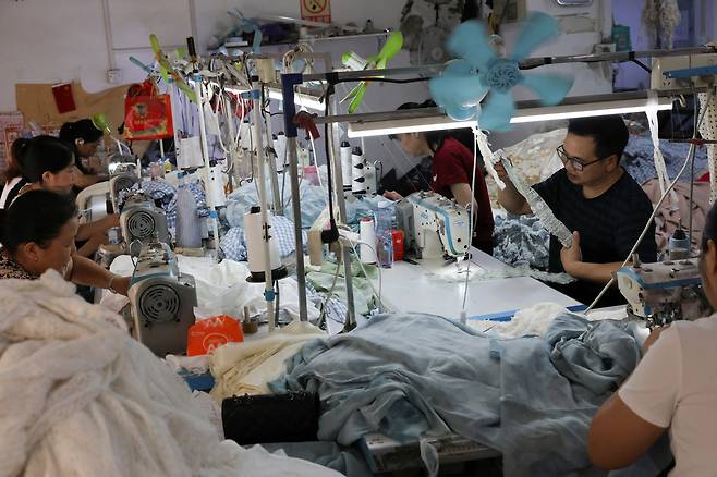 10일,중국 광둥성 광저우시 판위구의 한 섬유 공장에서 사람들이 일하고 있다. [AP]