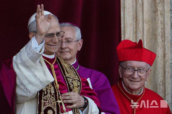 [바티칸=AP/뉴시스] 8일(현지 시간) 제267대 교황으로 선출된 미국의 로버트 프랜시스 프레보스트(69) 추기경이 선출 직후 바티칸 성베드로 대성당 중앙 '강복의 발코니'에서 인사하고 있다. 새 교황의 즉위명은 '레오 14세'로  '레오'는 라틴어로 '사자'를 뜻한다. 2025.05.09.