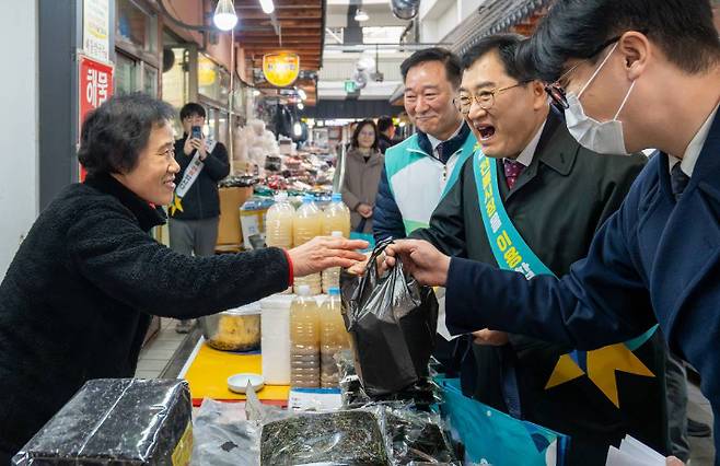 주낙영 경주시장이 지역 전통시장을 찾아 상인과 인사를 나누며 물건을 구입하고 있다. 경주시 제공