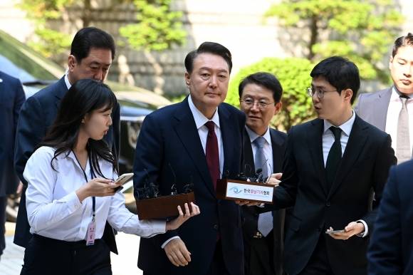 취재진에 둘러싸여 법정 향하는 윤석열 전 대통령 - 윤석열 전 대통령이 12일 오전 서울 서초구 서울중앙지법에서 열린 내란 우두머리 혐의, 직권남용 권리행사방해 혐의 사건 3차 공판에 출석하고 있다. 2025.5.12 사진공동취재단