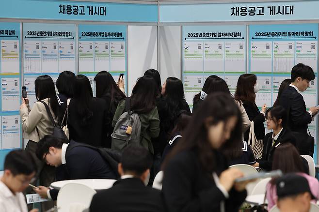 지난달 23일 서울 강남구 코엑스에서 열린 2025 중견기업 일자리 박람회를 찾은 구직자들이 채용공고 게시물을 보고 있다. ⓒ연합뉴스