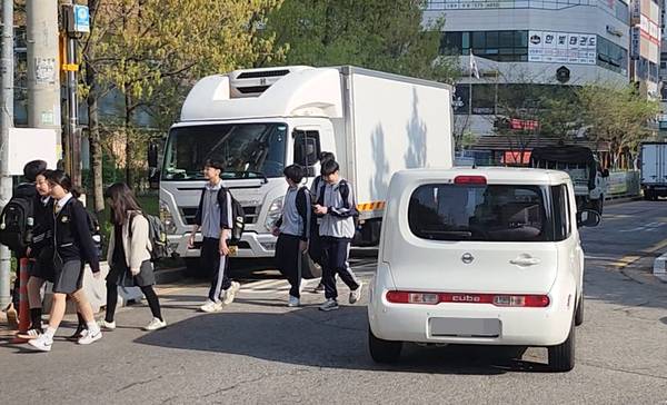 인천 서구 신현여중 학생들이 달리는 차량을 피해 등교하고 있다. /신현여중 제공