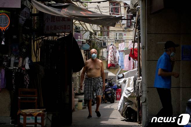20일(현지시간) 중국 상하이에 한 주택가에서 상의를 벗은 남성이 걸어가고 있다. 지난주 상하이는 40도를 웃도는 무더위로 149년만에 최고 기온을 갈아치웠다. ⓒ 로이터=뉴스1 ⓒ News1 유민주 기자