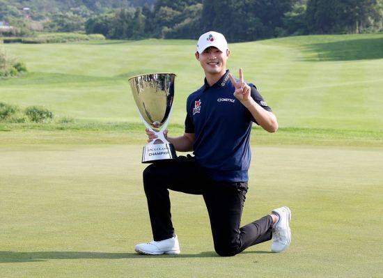 배용준이 KPGA 클래식 우승 직후 트로피를 무릎에 놓고 환하게 웃고 있다. KPGA