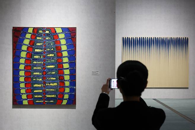 국립현대미술관 서울관 상설전에서 한 관람객이 하인두의 '만다라'(왼쪽)와 이우환의 '선으로부터'를 카메라에 담고 있다. /뉴시스