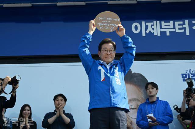 이재명 더불어민주당 대선 후보가 12일 경기 화성시 동탄센트럴파크에서 열린 집중유세에 참석해 자신의 서명이 담긴 반도체 웨이퍼를 들어 보이고 있다. 고영권 기자