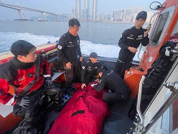 13일 부산 남항대교 아래 해상에 빠진 A씨를 부산해양경찰서 소속 경찰관이 구조해 상태를 확인하고 있다. [사진=부산해양경찰서]
