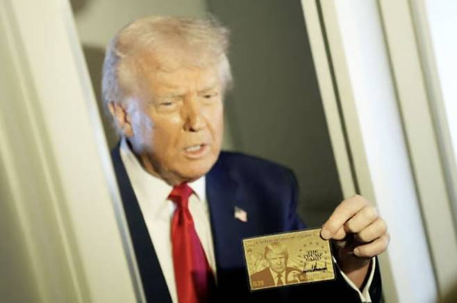 도널드 트럼프 미국 대통령이 전용기 에어포스원 기내에서 70억원대 영주권 카드인 '골드 카드'를 보여주고 있다. 사진=로이터 연합뉴스