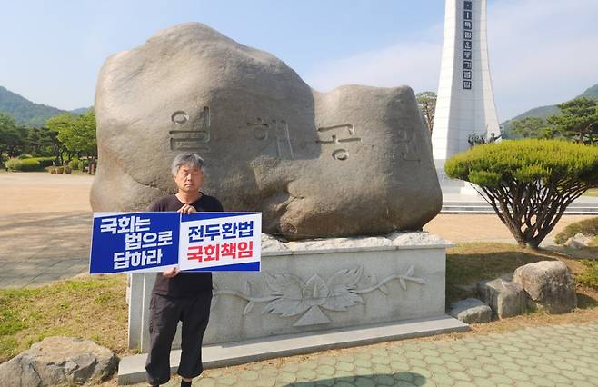 ‘생명의 숲 되찾기 합천군민운동본부’ 소속 한 회원이 13일 경남 합천읍 일해공원 표지석 앞에서 전두환 미화 공원 폐지를 촉구하고 있다. 합천군민운동본부 제공