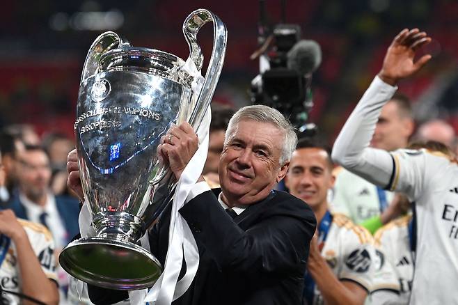 카를로 안첼로티 감독이 지난해 유럽축구연맹 챔피언스리그에서 레알 마드리드를 정상에 올려놓은 뒤 우승컵 ‘빅이어’를 들고 선수들과 기뻐하고 있다.   [AFP]