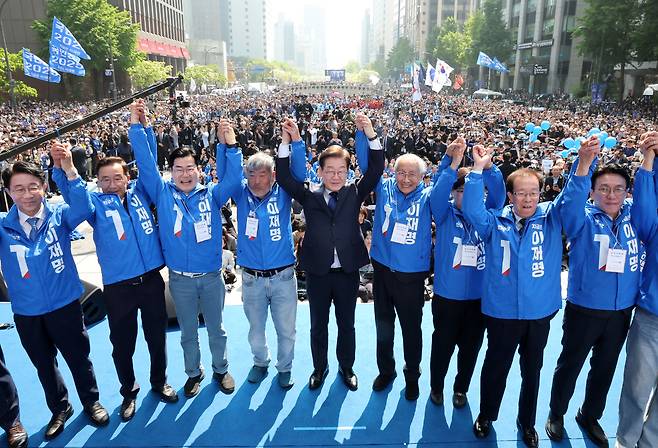 이재명 더불어민주당 대선후보가 12일 서울 청계광장 첫 유세에서 선대위원장단과 함께 손을 들어 인사하고 있다.  이상섭 기자