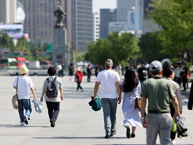 초여름 날씨를 보인 지난 12일 서울 광화문 광장에서 관광객과 시민들이 외투를 벗은 채 걷고 있다. [연합]
