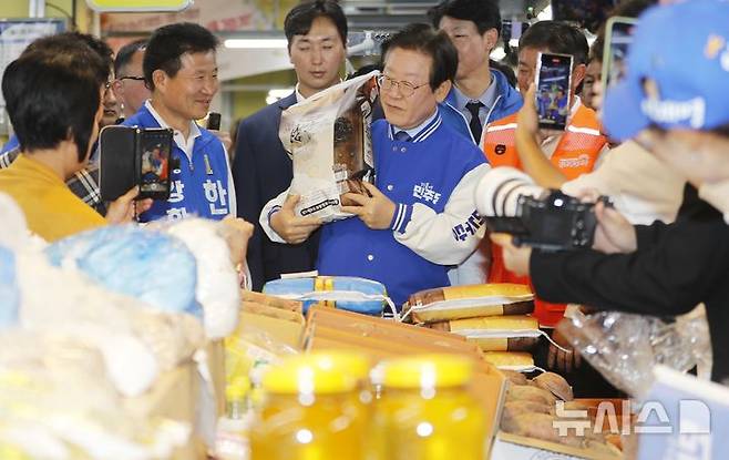 [인천=뉴시스] 김동영 기자 = 사진은 이재명 더불어민주당 대통령 선거 후보가 지난해 10월 5일 낮 인천 강화군 강화풍물시장에서 강화섬쌀을 들어 올리고 있는 모습. 2024.10.05. dy0121@newsis.com