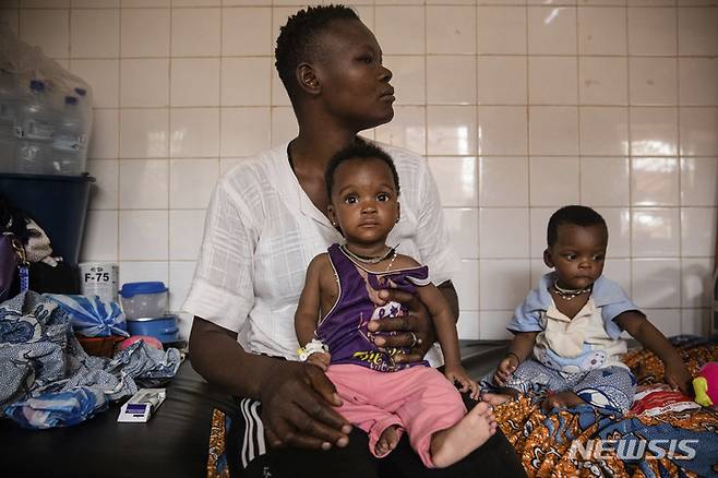 [와가두구( 부르키나 파소)=AP/뉴시스]부르키나 파소의 굶주린 아이들이  영양실조 치료를 받기 위해 수도 와가두구의  병원 앞에 대기하고 있다.  알카에다와 IS의 테러와 내전으로 이곳 주민들  63만명이 기아 상태로 내몰리고 전투와 굶주림으로 목숨을 잃고 있다. 2025. 05.13.