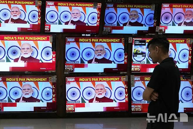 [뭄바이=AP/뉴시스]12일(현지 시간) 인도의 뭄마이의 한 쇼핑몰에서 TV를 통해 나렌드라 모디 총리의 대국민 연설이 생중계되고 있다. 20255.05.13.