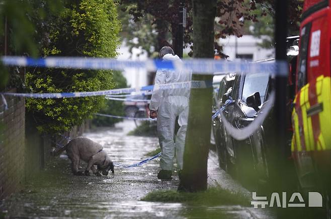 [런던=AP/뉴시스] 12일(현지 시간) 영국 런던 북부 켄티시타운에 있는 키어 스타머 총리 사저에서 화재가 발생한 후 한 경찰관이 탐지견과 함께 주변을 조사하고 있다. 현지 경찰은 이날 새벽 1시경 총리 사저에서 불이 나 출동한 소방대가 30분 내로 진압했으며 인명 피해는 없다고 밝혔다. 2025.05.13.