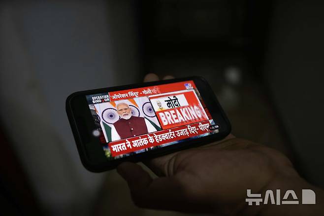 [잠무(인도)=AP/뉴시스]한 남성이 12일(현지시각) 인도 잠무에서 휴대전화로 나렌드라 모디 인도 총리의 대국민 연설을 듣고 있다. 그는 이날 미국의 중재로 파키스탄과 휴전한 이후 첫 공식 논평에서 "인도는 군사행동을 중단했을 뿐이며, 향후 또다시 테러가 발생하면 자체적으로 보복할 것"이라고 밝혔다. 2025.05.13.