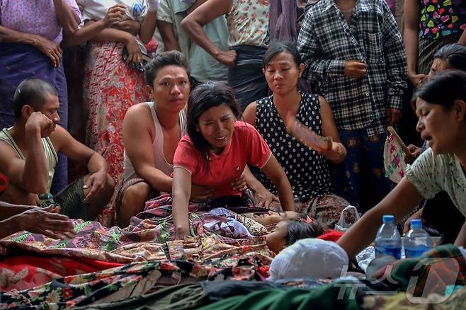 12일(현지시간) 미얀마 사가잉 지역 데파인타운십의 오헤 테인 트윈 마을에서 미얀마군의 폭격으로 사망한 희쟁자들의 장례식에서 유가족을 비롯한 참석자들이 오열하고 있다. ⓒ AFP=뉴스1