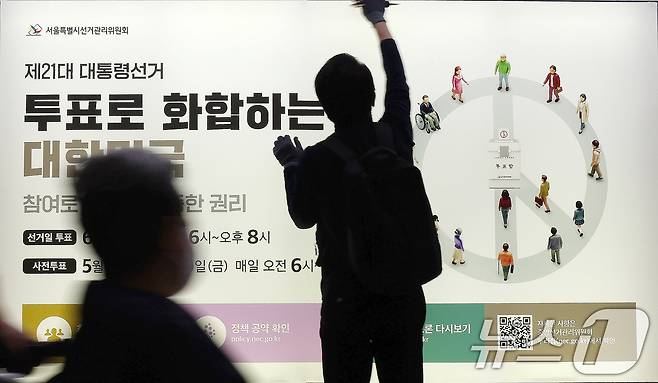 제21대 대통령선거를 20일 앞둔 14일 오전 서울 종로구 지하철 혜화역 승강장 스크린도어에 선관위 관계자들이 대선 홍보물 래핑작업을 하고 있다. 2025.5.14/뉴스1 ⓒ News1 박세연 기자