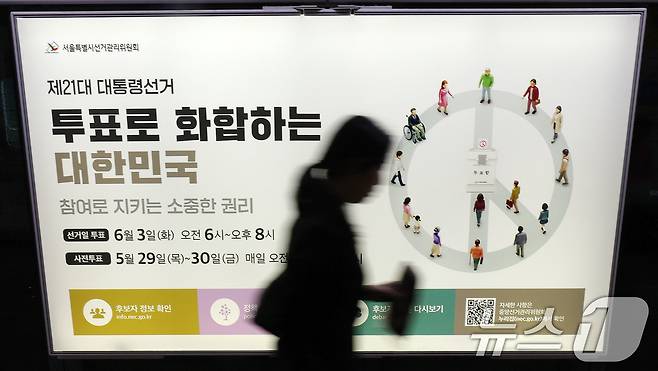 제21대 대통령선거를 20일 앞둔 14일 오전 서울 종로구 지하철 혜화역 승강장 스크린도어에 래핑된 대선 홍보물 앞으로 한 시민이 지나고 있다. 2025.5.14/뉴스1 ⓒ News1 박세연 기자