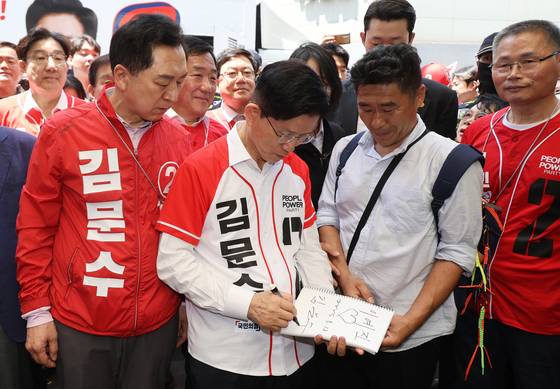 김문수 국민의힘 대선후보(왼쪽)가 13일 오후 울산 중구 성남동 뉴코아 팩토리아울렛 울산성남점 인근에서 열린 거리 유세를 마친 뒤 한 시민에게 사인을 해주고 있다. 임현동 기자
