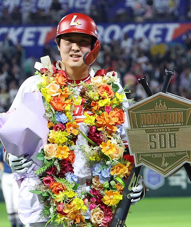 SSG 최정이 지난 13일 인천 NC전에서 프로야구 최초 통산 500홈런을 기록한 뒤 화환을 목에 걸고 축하를 받고 있다. 연합뉴스
