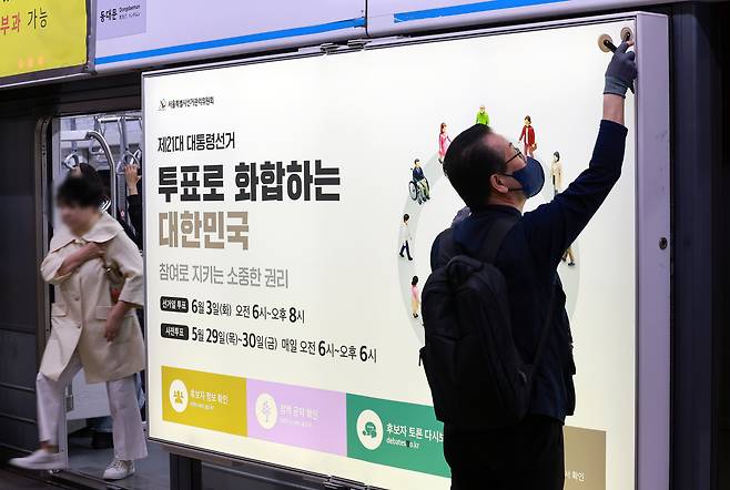 14일 서울 지하철 4호선 혜화역 하행선 승강장에서 서울특별시 선거관리위원회 관계자들이 제21대 대통령 선거 홍보물을 스크린도어에 래핑하는 작업을 벌이고 있다.  [연합]