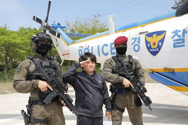 [부안=뉴시스] 14일 전북 부안군 위도에서 열린 항공 캠프 행사에서 한 어린이가 특공대원과 함께 경례를 취하며 사진을 찍고 있다. (사진=전북경찰청 제공) 2025.05.14. photo@newsis.com *재판매 및 DB 금지