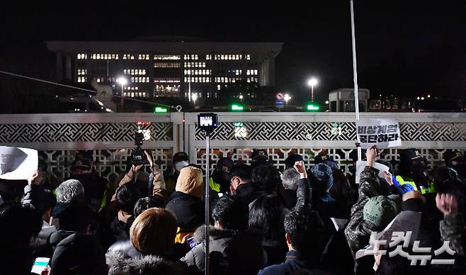 지난해 12월 4일 새벽 서울 여의도 국회의사당 정문 앞에서 군·경찰과 대치하던 시민들이 비상계엄 해제 요구 결의안이 가결되자 환호하고 있다. 류영주 기자