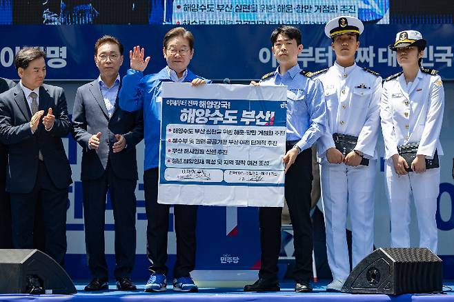 더불어민주당 이재명 대선후보가 14일 부산 부산진구 서면에서 열린 유세에서 부산 해양수도를 위한 공약에 서명한 뒤 들어보이고 있다. 연합뉴스