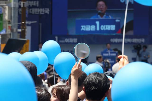 이재명 더불어민주당 대선 후보가 14일 부산 부산진구 서면거리에서 유권자들에게 지지를 호소하고 있는 가운데 지지자들이 파란풍선과 거울을 들고 있다. 부산=오승현 기자 2025.05.14
