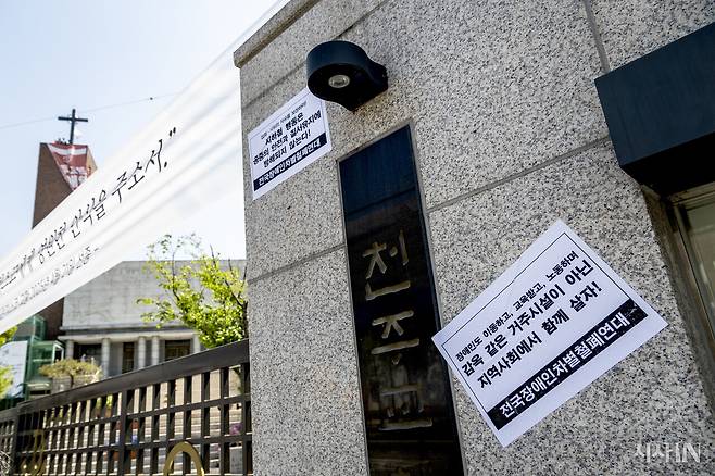 혜화동성당의 닫힌 문 너머로 종탑에서 농성 중인 세 활동가가 조그맣게 보인다. ⓒ시사IN 박미소