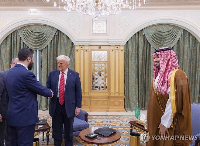 아메드 알샤라 시리아 대통령과 악수하는 도널드 트럼프 미 대통령(가운데) [Saudi Royal Palace/AP 연합뉴스 재판매 및 DB 금지]