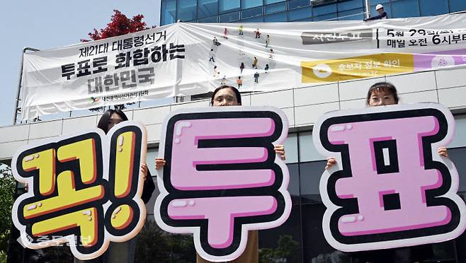 제21대 대통령선거를 앞둔 8일 대전시선관위 직원들이 청사에 내걸린 대형 홍보 현수막 앞에서 투표참여 캠페인을 벌이고 있다. [사진=이성희 기자]