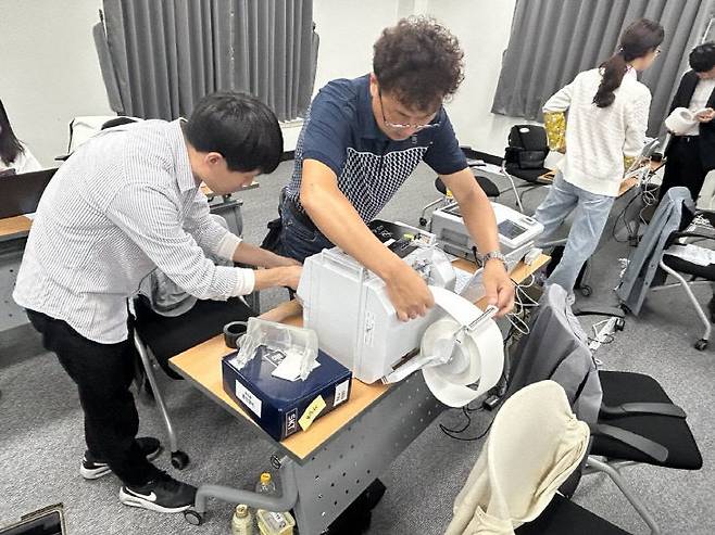 12일 제21대 대통령선거 사전투표소 사전투표관리관 및 장비담당사무원 교육이 실시된  서구선거관리위원회 대회의실에서 사무원들이 장비 사용 실습을 하고 있다. [출처=대전선거관리위원회]