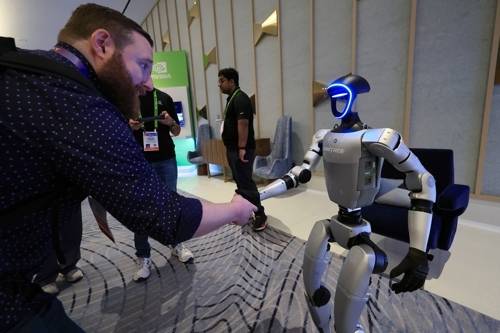 지난 1월 열린 세계 최대 가전·정보기술(IT) 전시회 CES 2025 엔비디아 전시관에서 휴머노이드 로봇 유니트리 G1이 관람객과 악수하고 있다. (사진=연합뉴스)