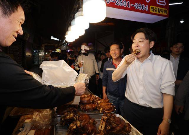 이준석(오른쪽) 개혁신당 대선 후보가 13일 대구 칠성시장에서 상인이 준 족발을 먹고 있다. 연합뉴스