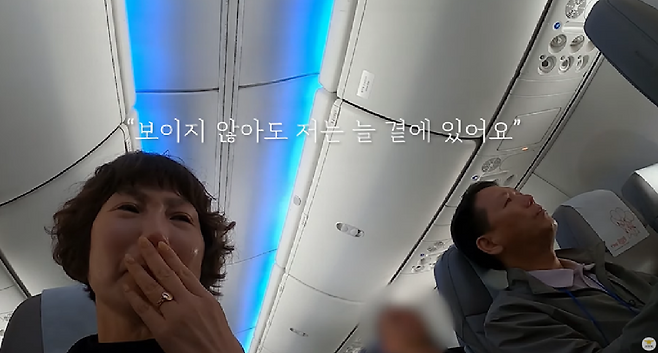 지난 9일 소방청이 마련한 순직 소방관 가족 '마음치유 여행'을 떠나는 항공기 안 모습. 순직 소방관의 목소리로 된 음성편지를 듣는 가족들. (소방청 제공)