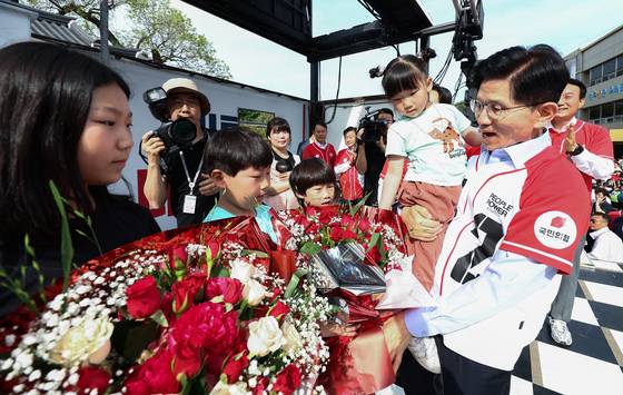 김문수 국민의힘 대통령 후보가 14일 경남 밀양시 밀양관아 앞에서 열린 유세에서 정용우, 손정혜 씨의 육남매 자녀들에게 꽃을 전달 받고 있다. 뉴스1