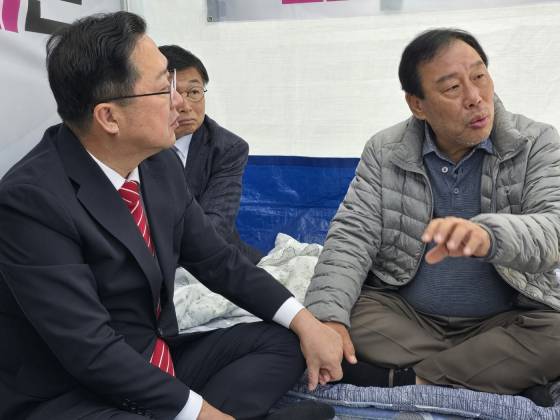 이장우 대전시장(왼쪽)이 세종시청 앞 서쪽 광장에서 단식중인 최민호 세종시장을 찾아 손을 잡고 대화하고 있다. 뉴스 1